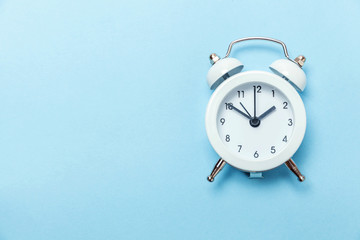 Ringing twin bell vintage classic alarm clock Isolated on blue pastel colorful trendy background. Rest hours time of life good morning night wake up awake concept. Flat lay top view copy space