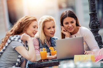 Three young women in cafe after shopping