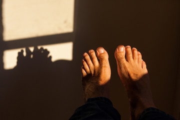 Feet at dusk with window light