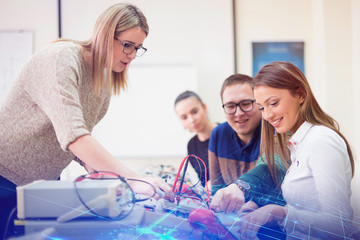 Group of young students  in technical vocational training with young female muslim teacher. Education and technology concept.