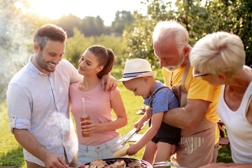 Happy family having barbecue with modern grill