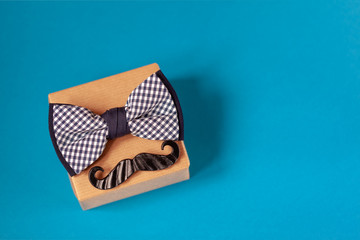 One gift box wrapped in craft paper and tied with the bow tie on blue background.