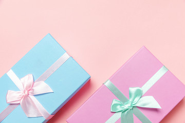 Christmas New Year birthday valentine celebration present romantic concept. Small gift box wrapped pink and blue paper isolated on pink pastel colorful trendy background. Flat lay top view copy space
