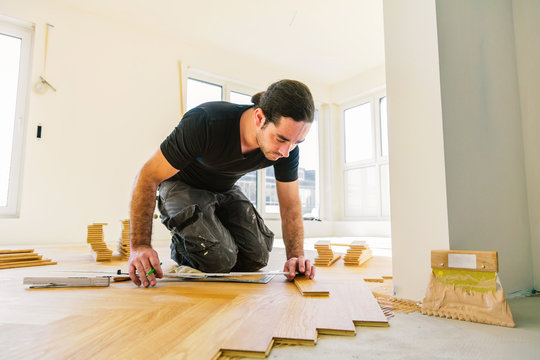 Handwerker bei der arbeit, fischgr&auml;t parkett verlegen 