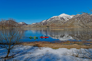 canoeists around the lake matese almost icy on a day from the blue sky. regional bench of the massif of matese in the region campania