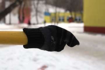 An old forgotten dirty glove hangs on a pipe near the school.
