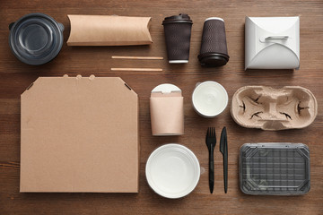 Fototapeta na wymiar Flat lay composition with paper bags and different takeaway items on wooden background. Space for design