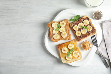 Tasty toasts with banana, mint and chia seeds served on table, top view. Space for text