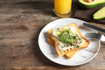 Tasty toasts with avocado, quail egg and chia seeds served on table. Space for text