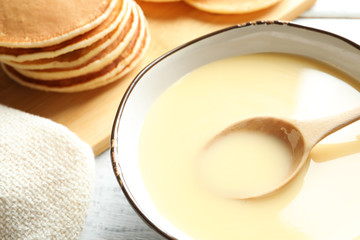 Bowl with condensed milk on table, closeup. Dairy products