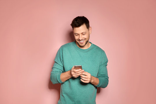 Handsome Man With Mobile Phone On Color Background