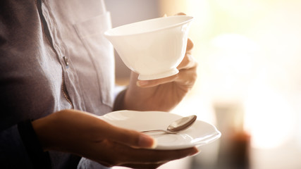 Asian women are holding a cup of coffee to drink.