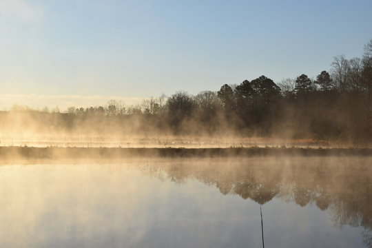 Steam fog rises over ponds on a cold spring morning in Mississippi