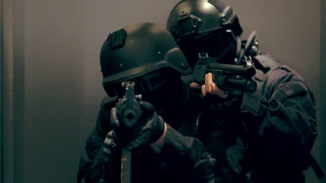 Two commandos with weapons out of the elevator