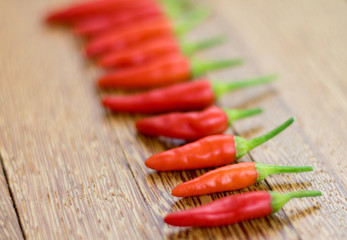 Red hot chili peppers on old wooden table.