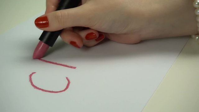 Close up woman writes words by lipstick.