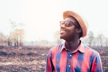 Portrait of african man standing at the dry field nature.