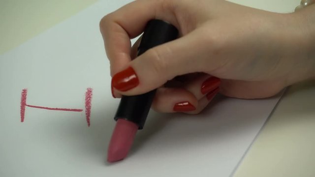 Close up woman writes words by lipstick.