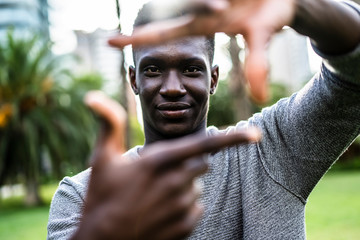Young man making a finger frame with his hands, around his face