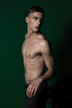 Half-naked young man in studio turning round