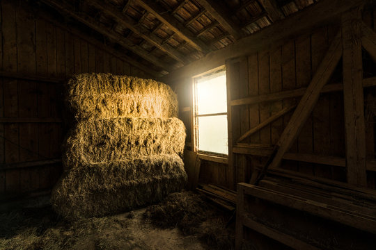 Traditional farm barn with bales of straws and light coming through window