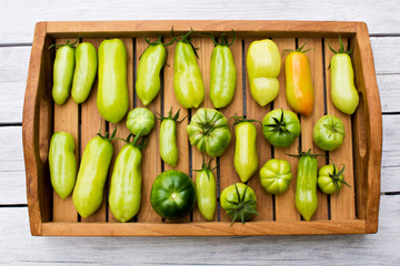 Tray with various tomatoes, stage of ripeness, unripe