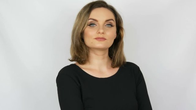 The beautiful sexy girl a bitch with flowing hair and blue eyes reproachfully looks into the camera on a white background