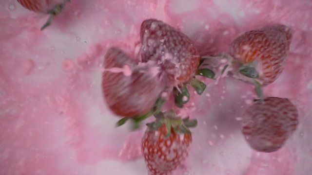 Falling paints with strawberries in slow motion.