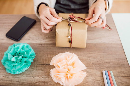 Young woman wrapping a gift in her studio