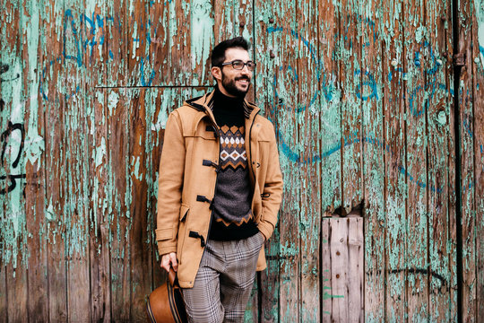 Spain, Igualada, smiling man standing at rundown wooden gate