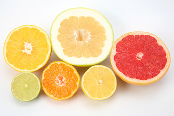 cut pieces of different citrus fruits on white background