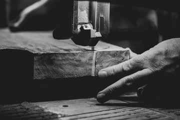 man working on a machine cutting wood