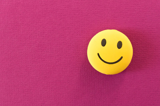 Funny smiley face on purple background. Positive mood. Empty text space.