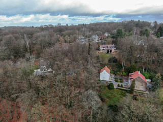 Aerial view of country side area in Walloon Brabant, Belgium, Luxury wealthy villas with garden surrounded by forest during winter season.