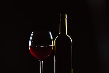  wine bottle and wine glass in a black background