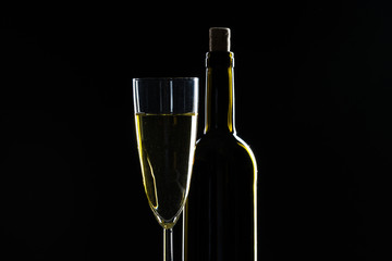  wine bottle and wine glass in a black background