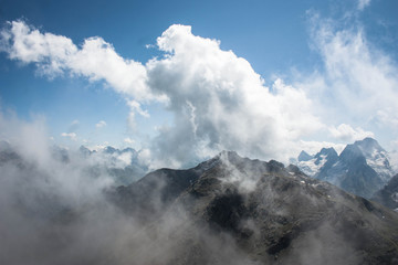 high steep mountains of the Caucasus above the clouds on a sunny day