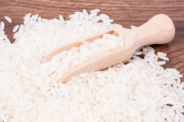 White rice with wooden scoop on board, healthy nutrition