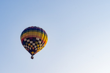 Hot air balloons flying on the blue sky during sunrise in morning.