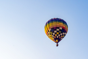 Hot air balloons flying on the blue sky during sunrise in morning.