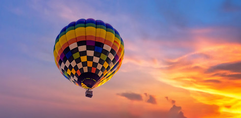 Obraz premium Hot air balloon flying during in colorful dramatic sky with cloud at sunset