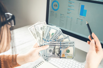 woman hand money with graph on computer screen