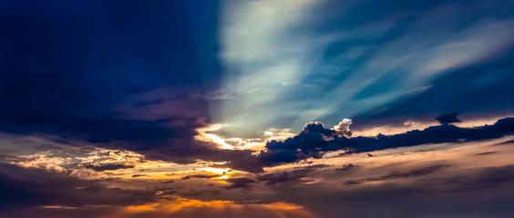 colorful dramatic sunset with sun rays shining trough the clouds in Newport Beach California