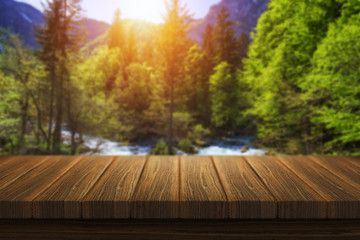 Empty wooden table in front of abstract blurred background in nature, can be used for display or montage your products. Mock up for display of product