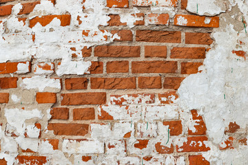 The texture of the old brick wall painted white with peeling paint