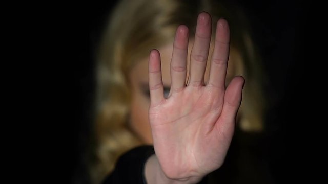 Woman showing stop sign with hand, against gender oppression, discrimination