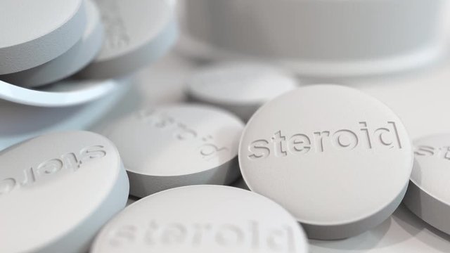 Close-up shot of pills with stamped STEROID text on them. 3D animation