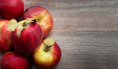 Ripe juicy red apples close up on wooden table. Top view. Copy space