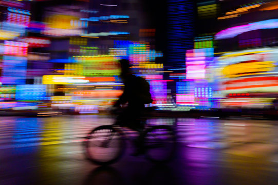 motion blurred of rider ride bicycle with neon light background