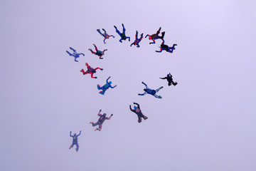 A group of skydivers is falling in the cloud.